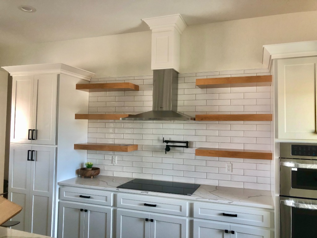 White Shaker Kitchen with Natural Oak Floating Shelves and Stainless Chimney Hood